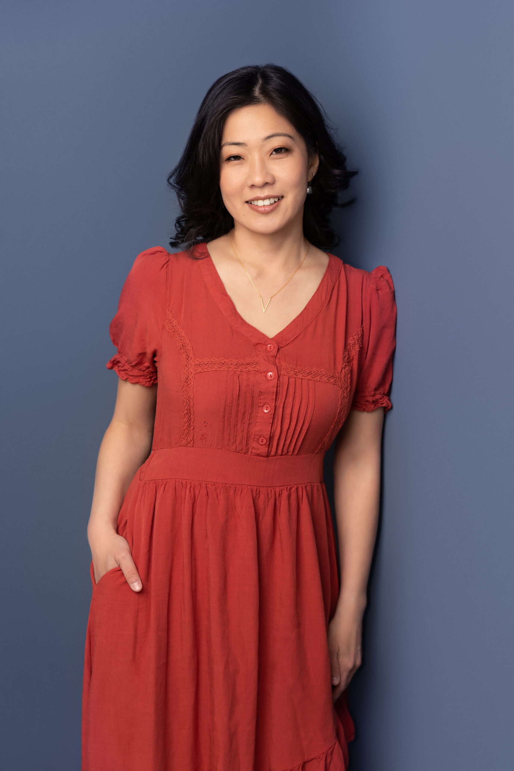 Becky Lee, founder of AskBecky, standing confidently in a red dress, representing professional virtual assistant, executive assistant, and Fractional COO services.